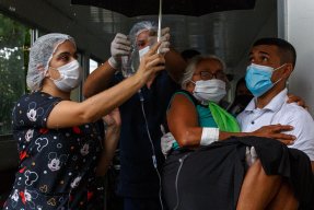 En kvinna med covid-19 bärs till ambulans för vidare transport till flygplatsen och därifrån till sjukhuset i Manaus, Brasilien. 
