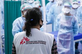 Läkaren Nisha Mohan står med ryggen mot kameran och pratar med personal på vårt  temporärt sjukhus i Patna, Indien.