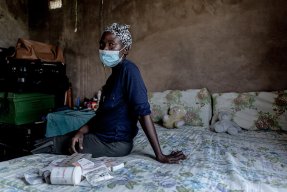 Phenduka Mtshali, som har läkemedelsresistent tuberkulos, sitter på sängen i sitt hem i Mbongolwane, Sydafrika.