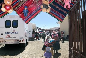 Två kvinnor och ett barn går förbi en ambulans från Läkare Utan Gränser i staden El Alto, granne med huvudstaden La Paz