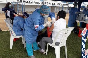 Personal från Läkare Utan Gränser vaccinerar en kvinna i Peru mot covid-19.