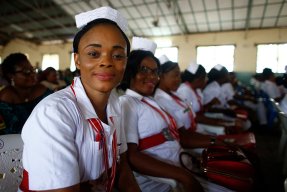 Sjuksköterskor och barnmorskor sitter på rad vid en examensceremoni i Sierra Leone.