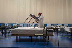 En av våra anställda sätter upp bord och sjukhussängar i vårt provisoriska covid-19-center i Leganés i Spanien, 2020. 