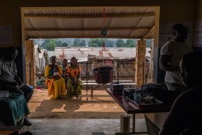 Innifrån en vårdcentral i byn Nzacko, Centralafrikanska republiken. Utanför sitter tre kvinnor på en bänk och väntar på sin tur.