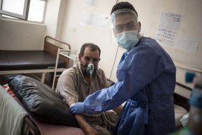 En sjukvårdsanställd tittar till en patient som får syrgas på sjukhuset i Raqqa i nordösta Syrien. 