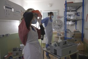 Två medarbetare från Läkare Utan Gränser sätter på sig skyddsutrustning för att arbeta med covid-19-patienter i London, Storbritannien.
