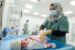 En nyfödd bebis på Nablus sjukhus i västa Mosul, Irak, sveps in i en filt av en sjukvårdspersonal.
