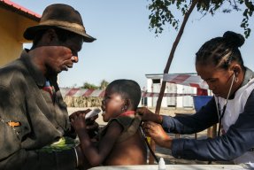 En man ger ett näringsberikat kex till sin femåriga dotter som är undernärd. Samtidigt undersöker en kvinnlig läkare barnet med ett stetoskop. Undersökningen sker under bar himmel i södra Madagascar.