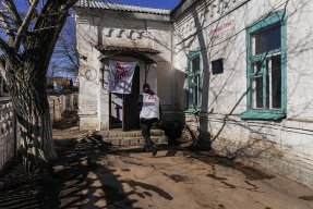 En anställd från Läkare Utan Gränser går in i ett hus i byn Starohnativka, Ukraina.