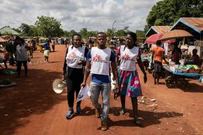 Tre hälsoinformatörer från Läkare Utan Gränser går på en gata i delstaten Ebonyi i sydöstra Nigeria.