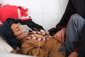 En pojke som har mässling får syrgas och ligger på en säng på Boost sjukhus, Afghanistan.