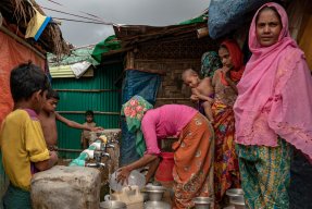 Kvinnor och barn står vid en vattenpost i lägret Jamtoli i Cox's Bazar i Bangladesh.