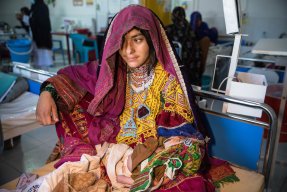 Ahmad, som är en och en halv månad gammal, är undernärd. Han ligger si sin mamma Bibi Hajiras knä på Boost sjukhus, Afghanistan.