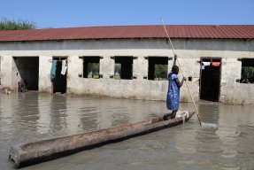 En kvinna tar sig fram med hjälp av en kanot efter översvämningar som drabbade Old Fangak, Sydsudan. 