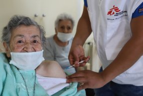 En äldre kvinna blir vaccinerad. 