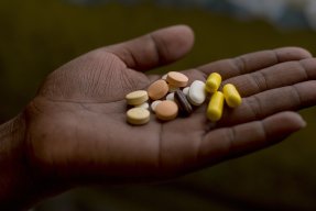 En patient med multiresistent tuberkulos visar upp sin dagliga dos mediciner.