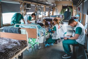 Personal på intensivvårdsavdelningen på Läkare Utan Gränsers tåg övervakar och stabiliserar en svårt krigsskadad patient under en resa från Pokvrosk i östra Ukraina till Lviv i västra Ukraina.