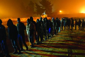 Människor köar för att få mat vid Dhar el-Jebel-förvaret i Libyen. 