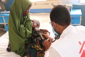 Läkaren Ahmed Ilyas undersöker lilla Saidya, som har mässling.