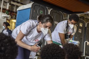 Två personer från Läkare Utan Gränser undersöker personer som inte syns på bilden.