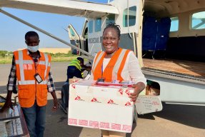 Stella utanför ett flygplan hållandes i ett paket