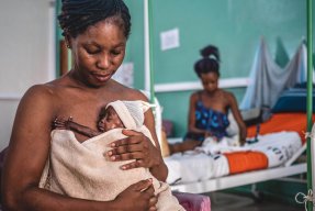 Ett nyfött barn ligger tajt mot sin mammas bröstkorg. 