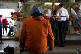 Ombord räddningsfartyget Geo Barents sitter en person med ryggen mot kameran