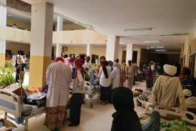 En sjukhusbyggnad full med folk i Sudan. 