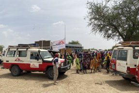 jeepar och människor i ett flyktingläger för sudaneser i Tchad