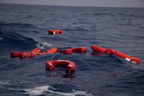 Flera flytvästar flytter på ett öppet hav med inga båter i bakgrunden