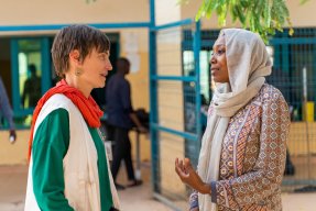 Två kvinnor pratar med varandra, den ena har en Läkare Utan Gränser väst på sig.