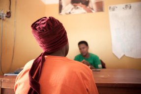 bild tagen bakifrån på en kvinna som sitter framför ett skrivbord