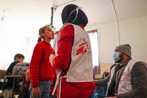 En kvinna i Läkare Utan Gränser väst ger en flicka ett oralt vaccin