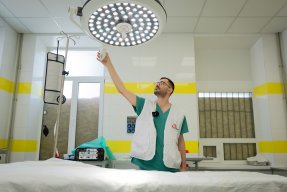 Läkare står vid en tom sjukhussäng och justerar ljuset över sängen