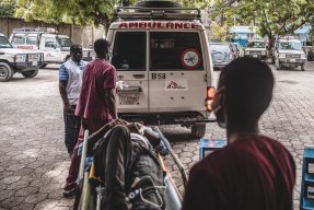 En man på bår bärs in i Läkare Utan Gränsers ambulans. 