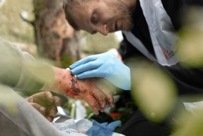 Sjukvårdare ger sårvård i skogen