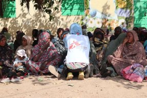 Kvinnor sitter i skuggan av ett träd