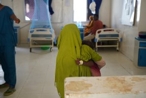 En liten pojke håller i sin syster inne på barnavårdsavdelningen i Somalia.