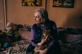 En kvinna med en katt i famnen.