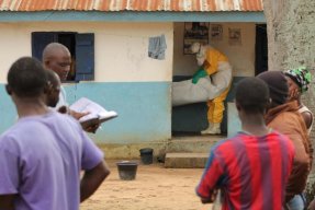 En av våra medarbetare tar hand om en avliden flicka som har dött i sitt hem i Foyaregionen i Liberia. Kroppen desinficeras och läggs i en body bag innan den kan begravas. FOTO: Martin Zinggl.