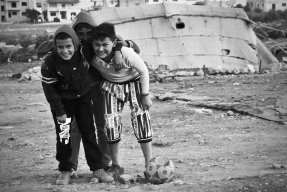 Mahmoud och hans vänner spelar fotboll. 