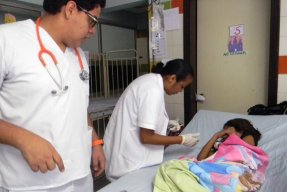 Personal på sjukhuset i San Pedro Sula tar hand om en liten patient med denguefeber. 