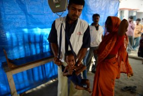 I Bihar i Indien behandlar vi undernäring. Vår personal väger ett barn.