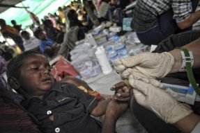 Ett litet barn får ett blodprov taget i fingret för att testa honom för malaria.