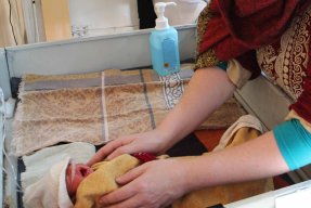 En barnmorska tar hand om en nyfödd på sjukhuset i Khost, Afghanistan.