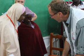 En kirurg från Läkare Utan Gränser pratar med en patient som lider av sjukdomen noma. 