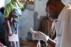 En sjuksköterska granskar ett malariatest på en vårdcentral i Remeka, Kongo-Kinshasa. 