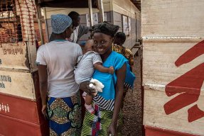 En mamma och hennes barn vid ingången till Castor sjukhus, Centralafrikanska republiken.