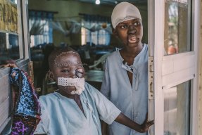 Åttaåriga Umar och femtonåriga Adamu står vid ingången till den postoperativa avdelningen på Sokoto sjukhus.