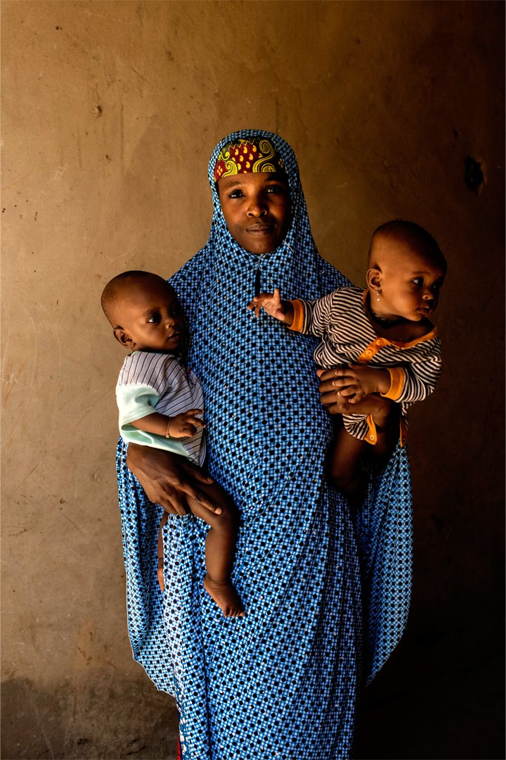 En kvinna håller i två barn